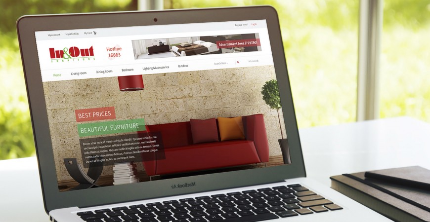 In&out Furniture website home page on a Macbook Air on top of a white desk